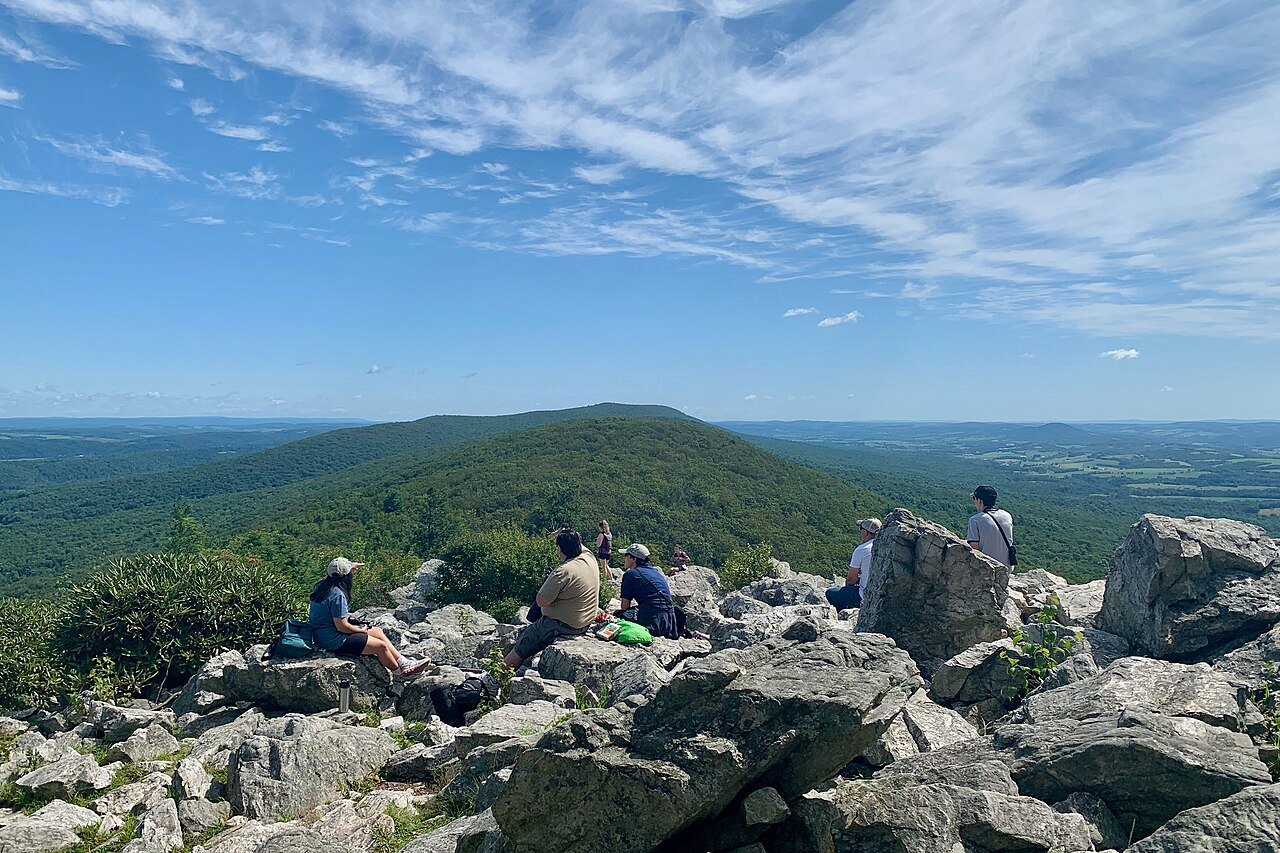 Visitors looking across wooded ridges at the North Lookout of Hawk Mountain Sanctuary