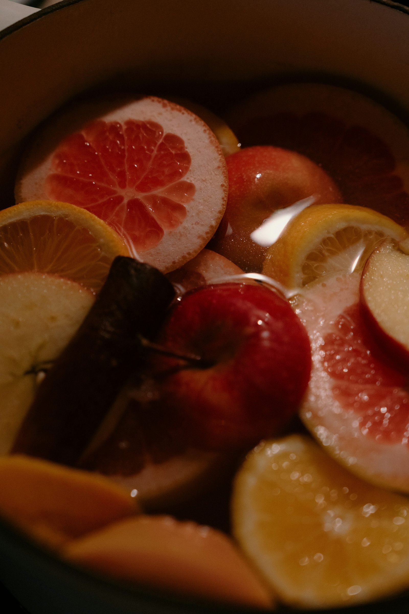 Citrus slices and cinnamon in a holiday simmer pot, illustrating the ingredients used in a boilo base