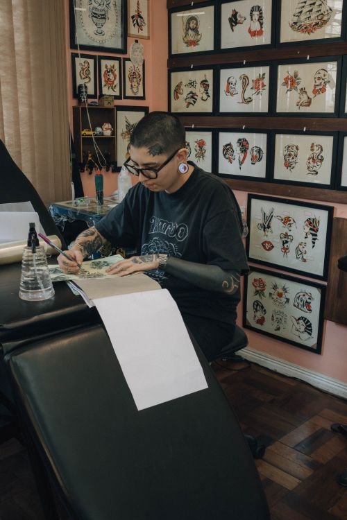 Illustrative stock photograph of a tattoo artist sketching a design; not an image from the Penn State Schuylkill exhibit